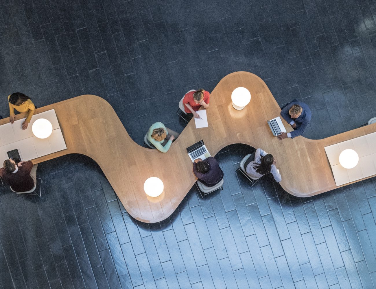 Overhead view of business meetings Panoramic overhead view of several business meetings going on in the communal area of a modern office building.